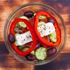 Greek salad is served with large pieces of cheese and vegetables