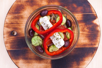 Greek salad is served with large pieces of cheese and vegetables