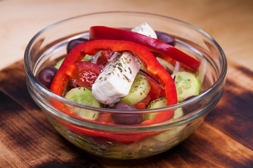 Greek salad is served with large pieces of cheese and vegetables