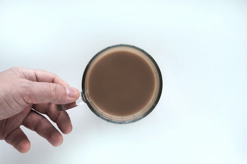 Energy boost concept. Hand holding a glass mug of coffee, isolated white background, top view.