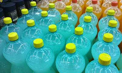 Soft drinks bottles meticulously aligned in a supermarket