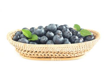 Fresh wild blueberries heap in wooden basket on white isolated background for wallpaper and all web design. Blueberry is healthy and delicious fruits which have high antioxidant and vitamin C.