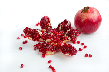 Cut-up tasty garnet pomegranate with seeds isolated on white background