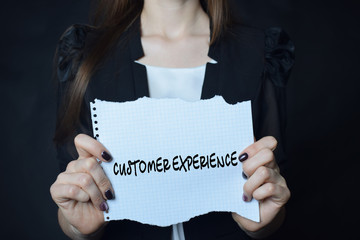 In the hands of a businessman a scrap of paper with the inscription:CUSTOMER EXPERIENCE