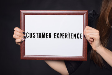 Fototapeta na wymiar In the hands of a businessman a frame with the inscription:CUSTOMER EXPERIENCE