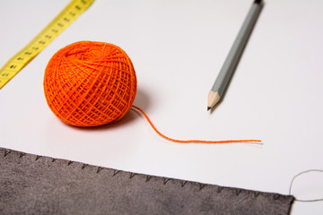 Background for tailor orange thread ribbon and pencil
