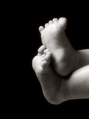 Fototapeta premium two little feet on isolated black background