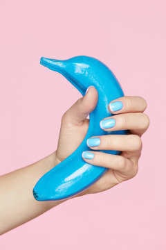 Nails Beauty. Hand With Blue Nails Holding Banana