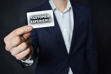 Businessman shows business card with the inscription:CUSTOMER EXPERIENCE