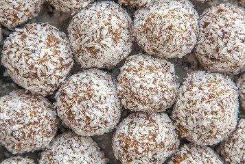 Healthy homemade sweet balls of dried fruits and nuts in coconut shavings.