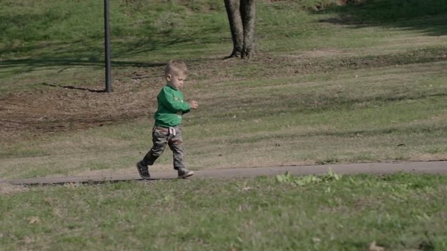 A little boy is walking in the park 4k