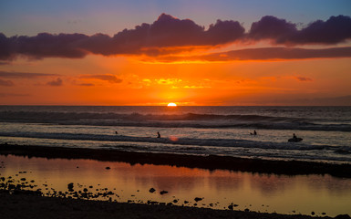 Sunset Background Ocean. Tropical Sunlight and Summer Sunset View. Colorful Background Sunset. Blue Waves near sea Resort. Sea sunset Background. Colorful Beach with Surfers on the Horizon. Landscape