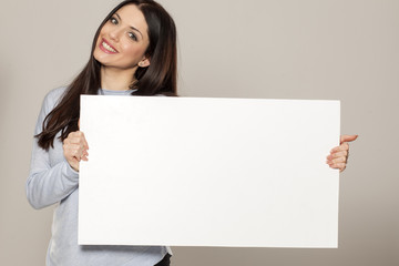 Happy woman showing empty blank paper card sign with copy space for text
