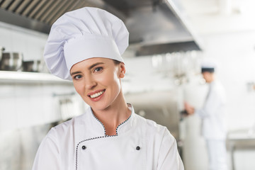 portrait of smiling chef looking at camera at restaurant kitchen