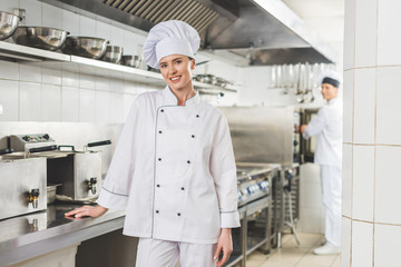 smiling chef looking at camera at restaurant kitchen