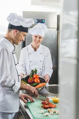 chef cutting vegetables at restaurant kitchen