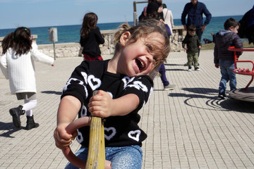 Fototapeta premium Little girl plays happy in a playground