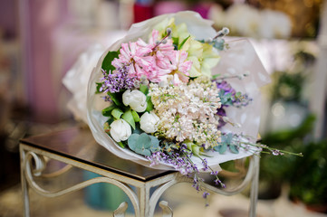Wonderful bouquet of white lilac and tulips decorated with green leaves