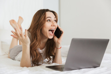 Portrait of a cheerful young woman talking on mobile phone