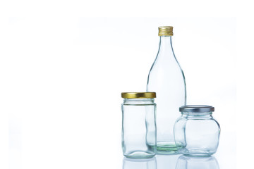 Clear glass bottles in various sizes and shapes with lids on white background