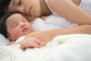 Obraz na płótnie Canvas Older sister and her newborn sister sleep.