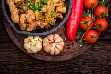 Fried pork in frying pan and vegetables