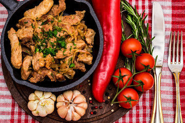 Fried pork in frying pan and vegetables