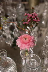 Table decorated with pink rosemary flower and carnation in glass crystal vases