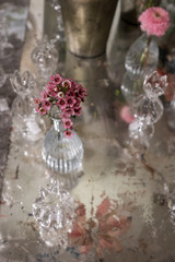 Table decorated with pink rosemary flower in glass crystal vase
