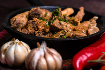Fried pork in frying pan and vegetables
