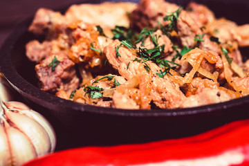 Fried pork in frying pan and vegetables