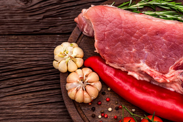 Raw pork steak with pepper, herbs and tomatoes