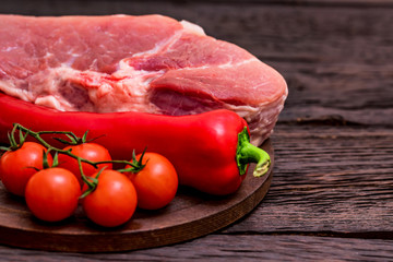 Raw pork steak with pepper, herbs and tomatoes