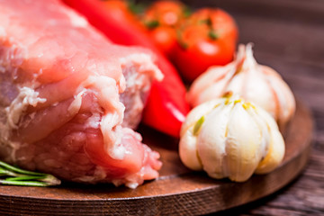 Raw pork steak with pepper, herbs and tomatoes
