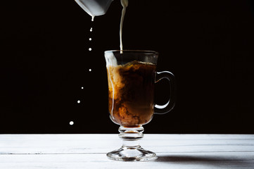 The moment pouring milk into coffee.