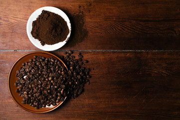 Coffee beans and coffee ground on dark wooden background