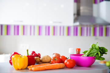 Fresh diverse colorful healthy vegetables being prepared to be cooked for breakfast on a counter in a very bright kitchen.