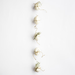 White minimalistic Easter eggs decorated with twine and flowers of gypsophila on a white background lined with a line. Easter concept. Top view, flat lay