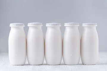 five bottles of drink yogurt on gray background