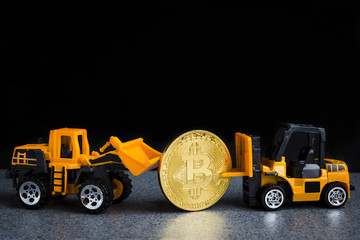 Bitcoin cryptocurrency mining concept. Blockchain technology. Miniature industrial machines with bitcoin. Dark background with copy space.