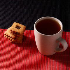 Cup of Tea with Cookies on style red and black background