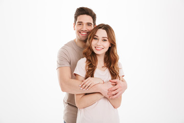 Young lovely couple boyfriend and girlfriend posing together with broad smile while man hugging...