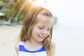 beautiful blond girl on the beach with a blue and white striped dress