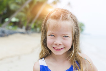 beautiful blond girl on the beach with a blue and white striped dress