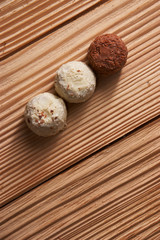 Macro. White and milk chocolate candies on a light wooden background
