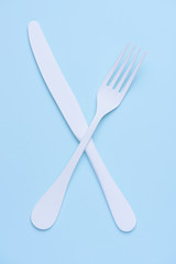 Croseed knife and fork symbol concept on trendy pastel blue background