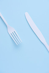 White new clean knife and fork on blue trendy pastel background