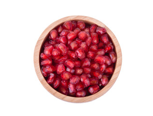 Pomegranate seeds in wooden bowl isolated on white background. Top view