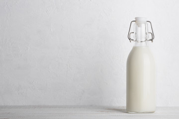 Bottle of milk with vintage swing top lock, closed, on white wooden table with copy space