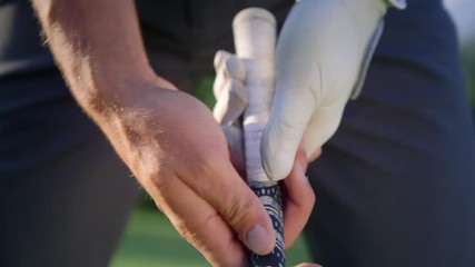Pro golfer, perfect grip. Pro golfer holding his club, adjusting the position of his fingers